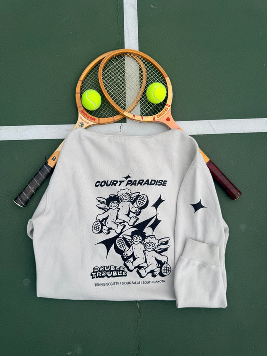Court Paradise Bone hoodie with Double Trouble cherub tennis print, crossed vintage racquets and balls on the court